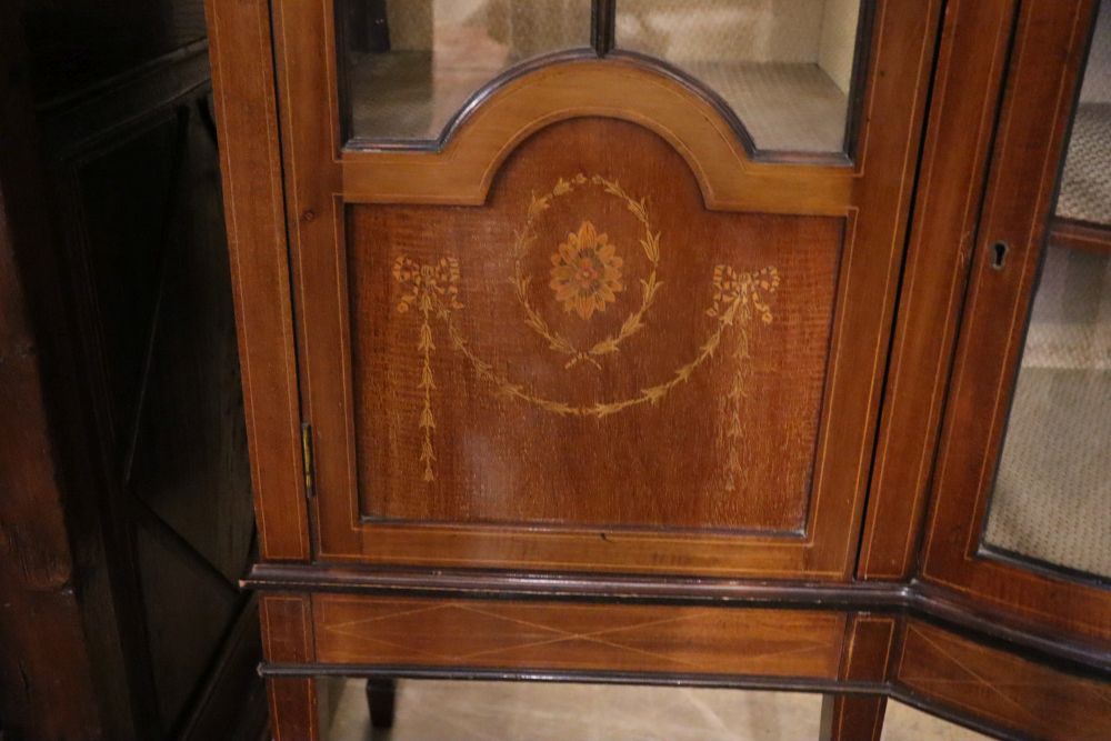 An Edwardian marquetry inlaid mahogany bow fronted display cabinet